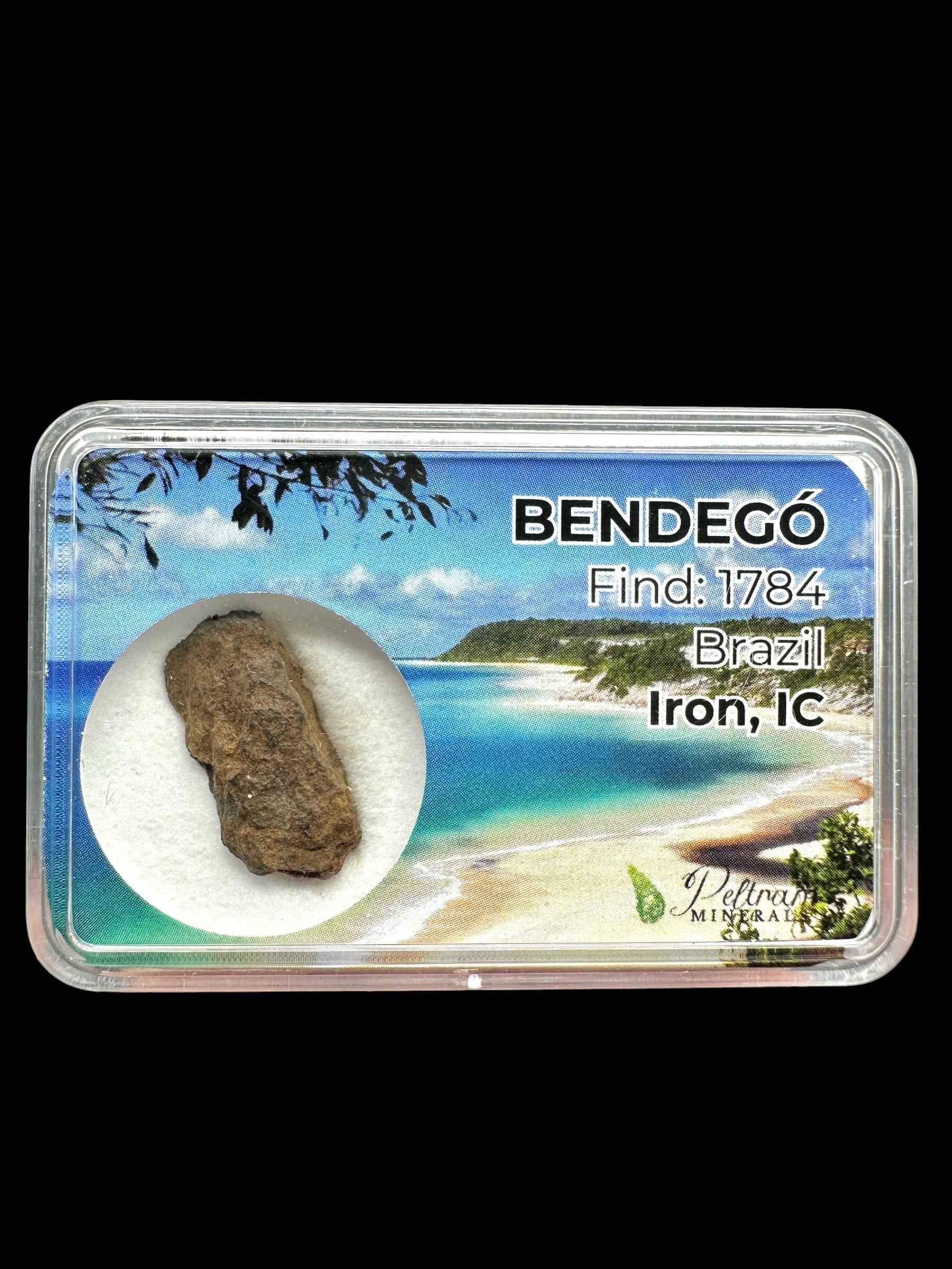 Frammento grezzo di meteorite Bendegó bruno-grigiastro in scatolina trasparente con etichetta Brazil Iron IC