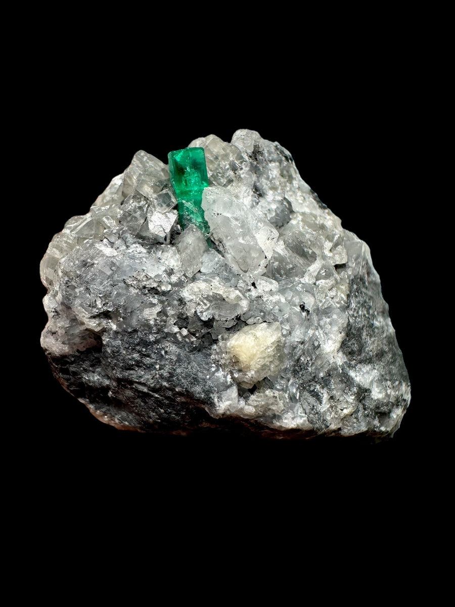 Smeraldo grezzo verde su matrice di calcite bianca e roccia scura, Muzo Boyacá, Colombia