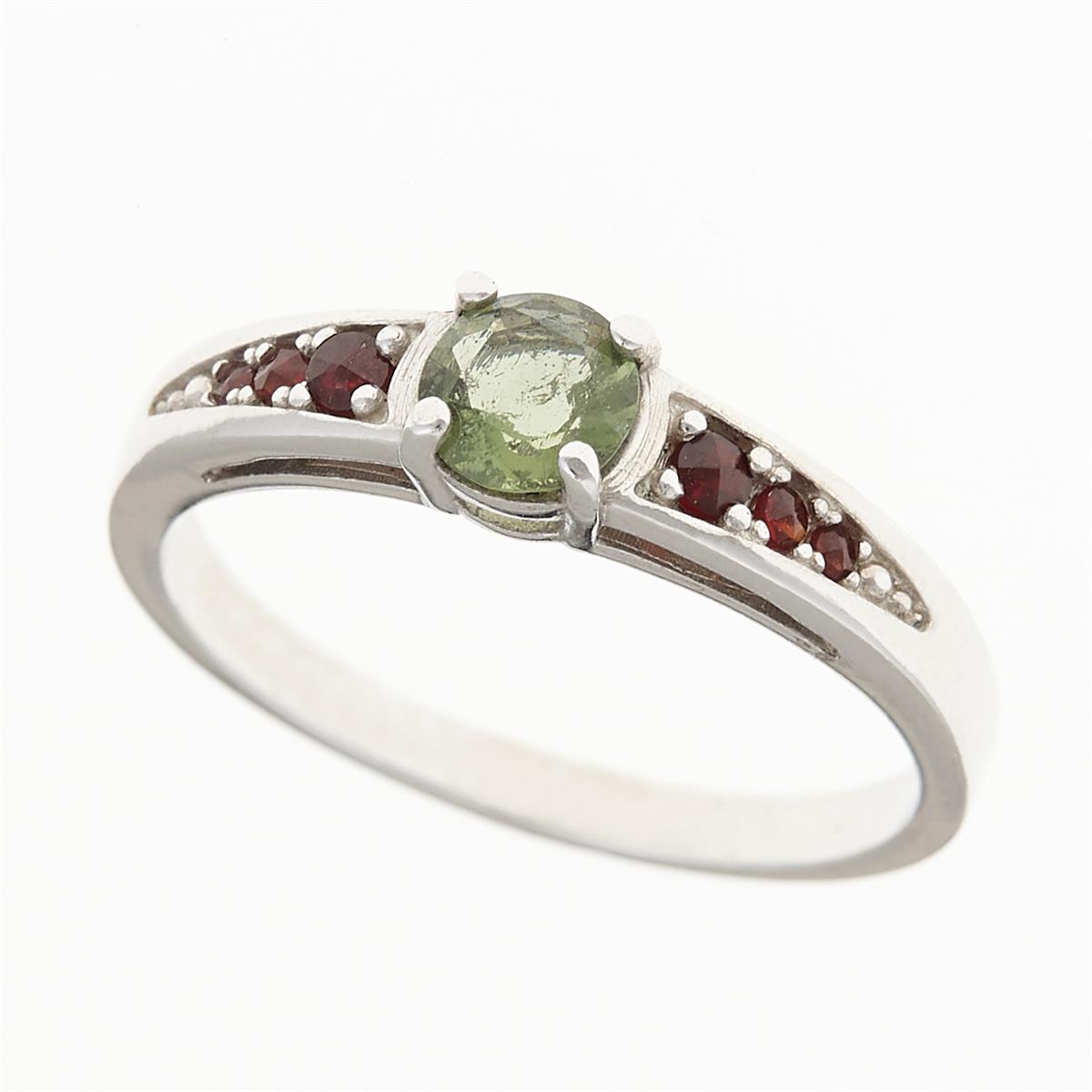 Anello in argento rodiato con moldavite grezza verde tonda al centro e sei granati rossi sulle spalle