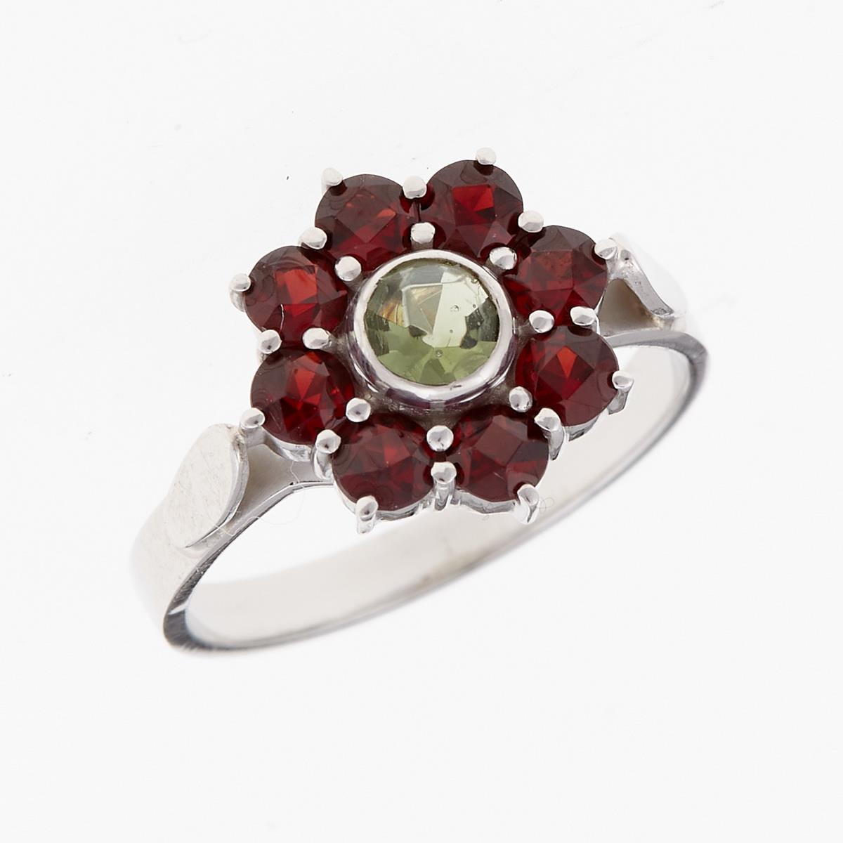Anello in argento rodiato con moldavite faccettata verde al centro e otto granati rossi disposti a rosetta