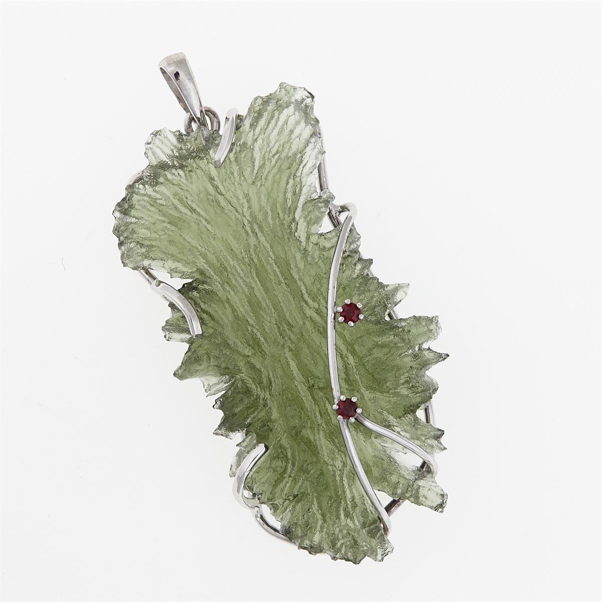 Pendente con moldavite grezza verde a forma di rana, bordi frastagliati, montatura in oro bianco e due granati rossi