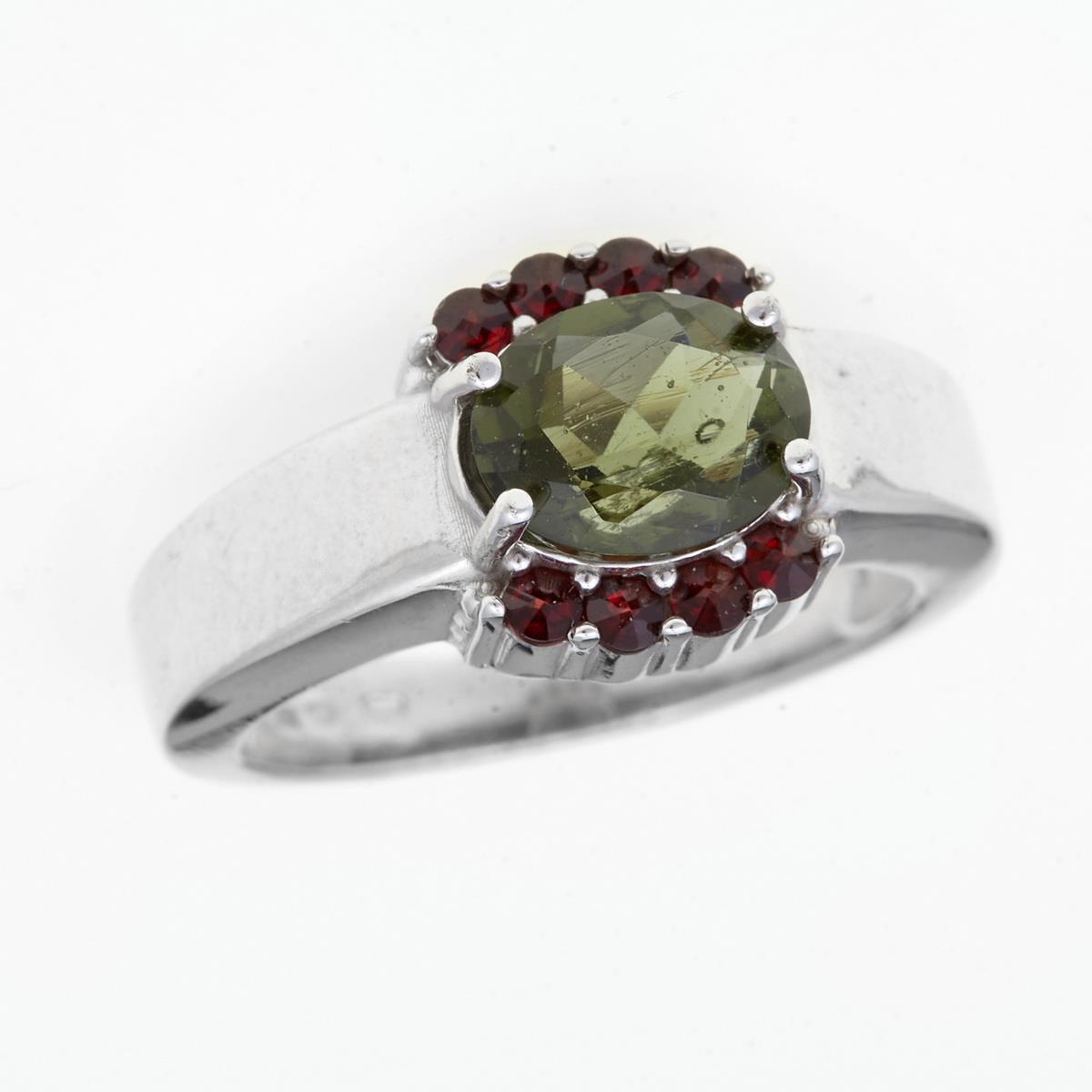 Anello in argento rodiato con moldavite ovale sfaccettata verde e due archi di granati rossi