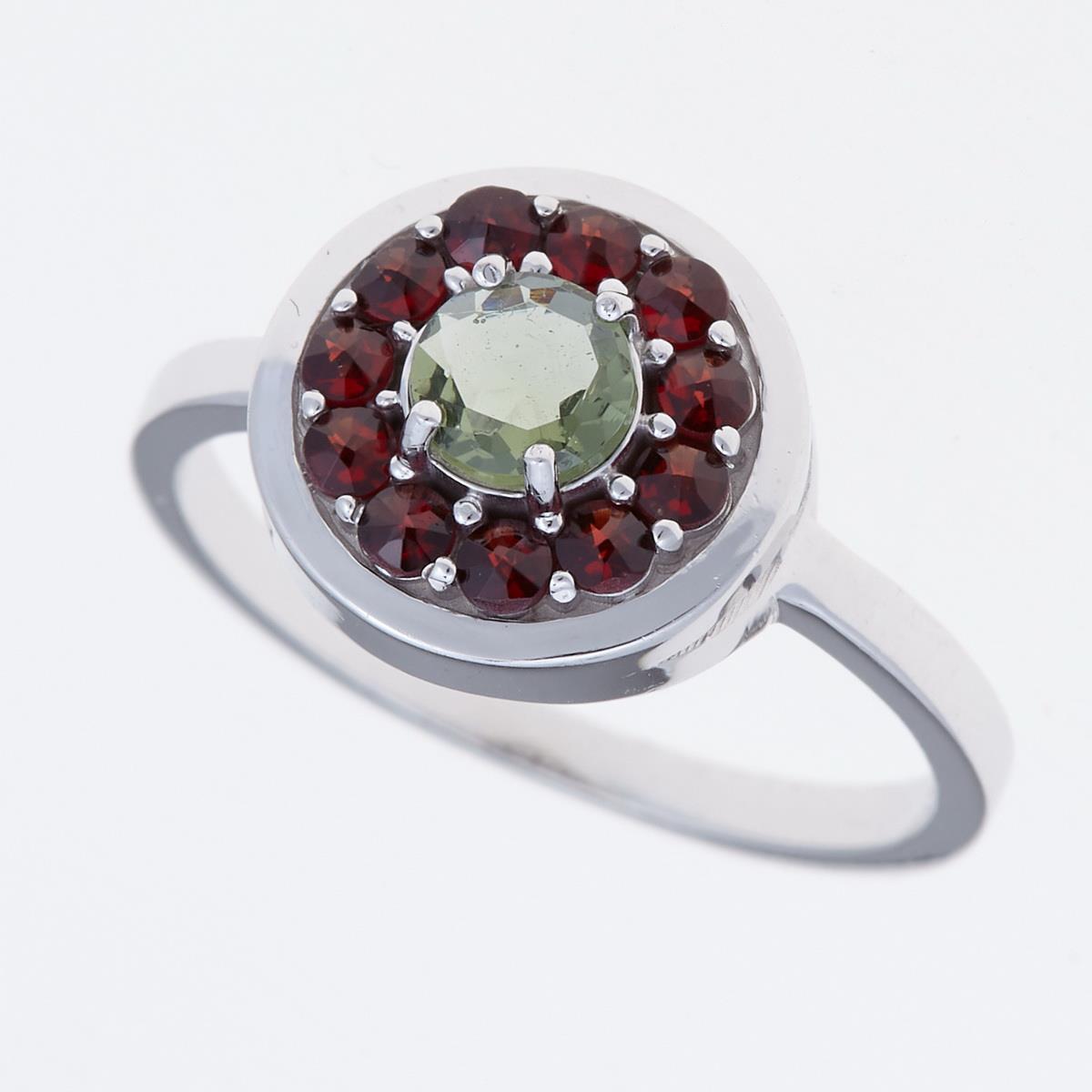 Anello in argento rodiato con moldavite verde sfaccettata al centro e corona di granati rossi