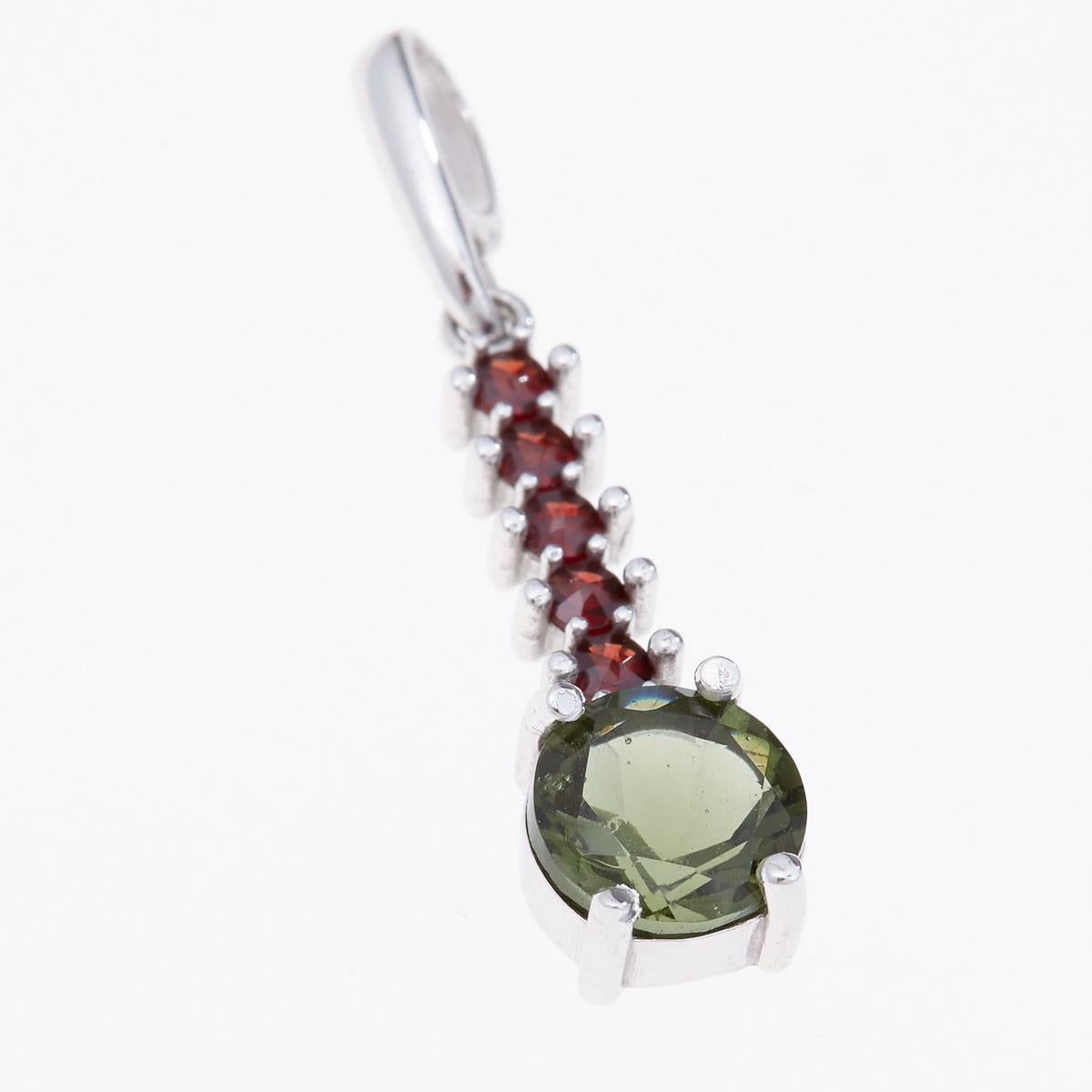 Pendente in argento rodiato con moldavite verde faccettata tonda e cinque granati rossi allineati