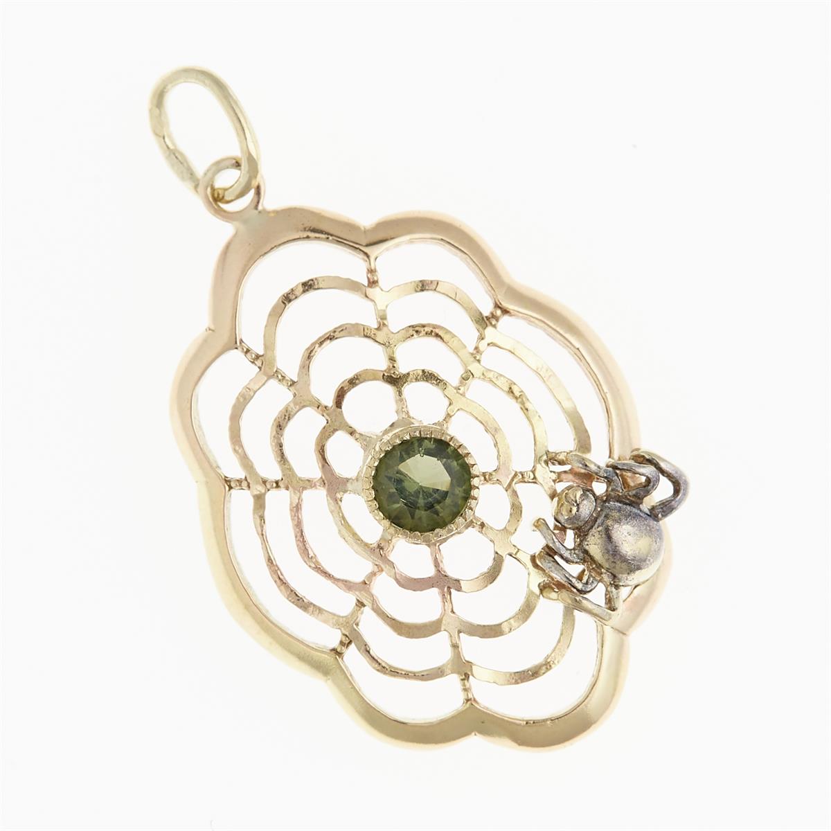 Pendente in oro traforato a ragnatela con moldavite verde faccettata al centro e ragno in oro bianco